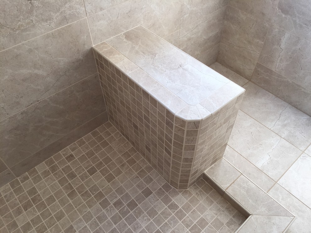 Photo of a mid-sized mediterranean master bathroom in Orange County with beaded inset cabinets, a corner shower, beige tile, porcelain tile and porcelain floors.