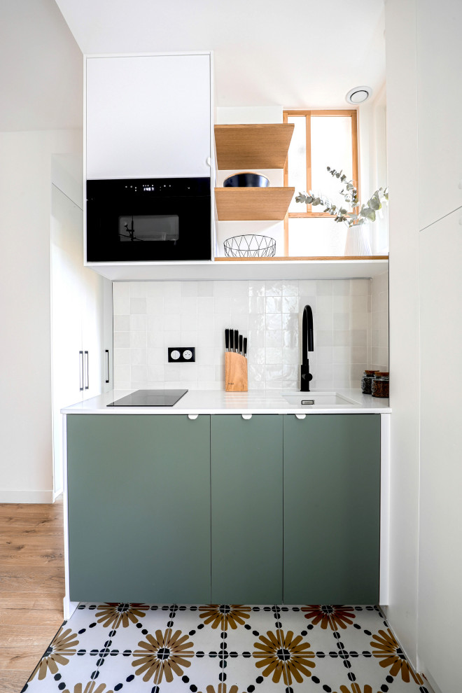 Idées déco pour une petite cuisine ouverte linéaire et blanche et bois scandinave avec un plan de travail en quartz, un électroménager noir et carreaux de ciment au sol.