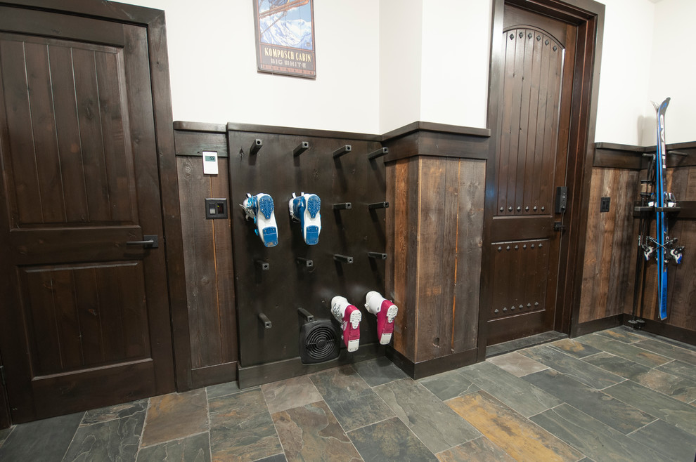 Inspiration for a large rustic slate floor and multicolored floor mudroom remodel with beige walls and a dark wood front door