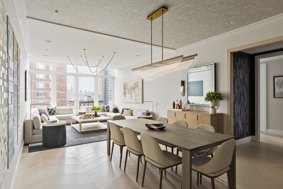 Foto di una sala da pranzo aperta verso il soggiorno contemporanea di medie dimensioni con pareti bianche e parquet chiaro