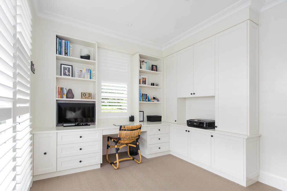 This is an example of a mid-sized transitional study room in Sydney with white walls, carpet, a built-in desk and beige floor.