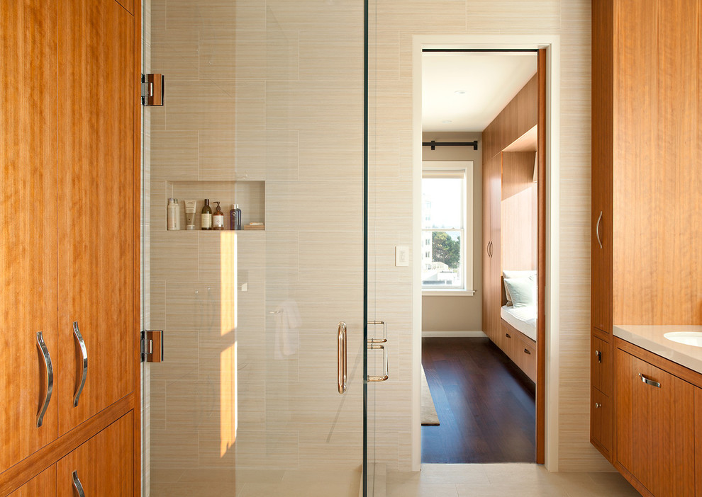 Photo of a contemporary master bathroom in San Francisco with flat-panel cabinets, medium wood cabinets, beige tile, beige walls, beige floor, a hinged shower door, beige benchtops, a niche and a floating vanity.