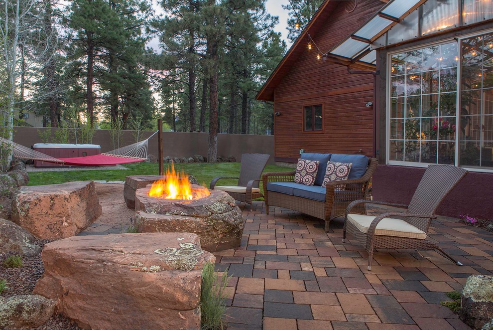 Inspiration for a large rustic backyard brick patio remodel in Phoenix with a fire pit and no cover