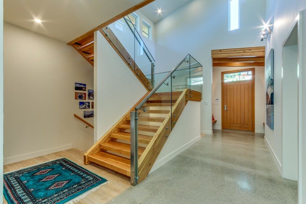 This is an example of a large contemporary wood curved staircase in Other with wood risers.