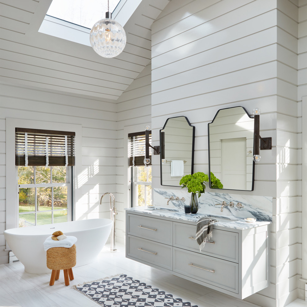 Cette image montre une grande salle de bain principale marine avec un placard avec porte à panneau encastré, des portes de placard blanches, une baignoire indépendante, une douche à l'italienne, un carrelage blanc, un mur blanc, un sol en marbre, un lavabo encastré, un plan de toilette en marbre, un sol blanc, une cabine de douche à porte battante, un plan de toilette blanc, une niche, meuble double vasque, meuble-lavabo suspendu, un plafond en lambris de bois et du lambris de bois.