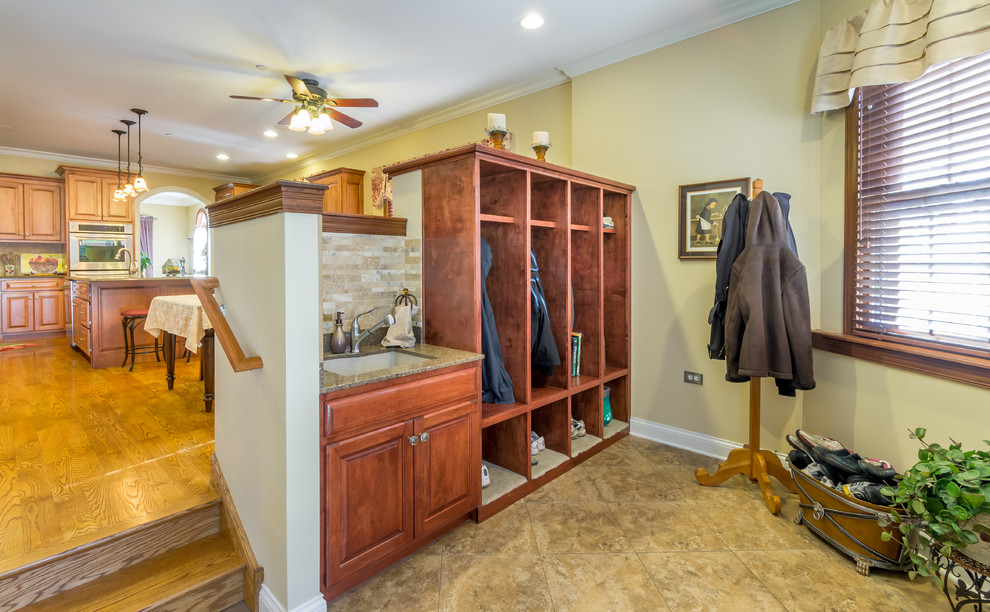 Inspiration for a mid-sized traditional mudroom in Chicago with beige walls, ceramic floors, a single front door, a medium wood front door, beige floor, wallpaper and wallpaper.