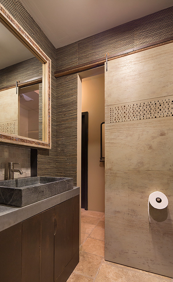 Mid-sized country powder room in San Francisco with flat-panel cabinets, dark wood cabinets, gray tile, stone tile, green walls, limestone floors and concrete benchtops.