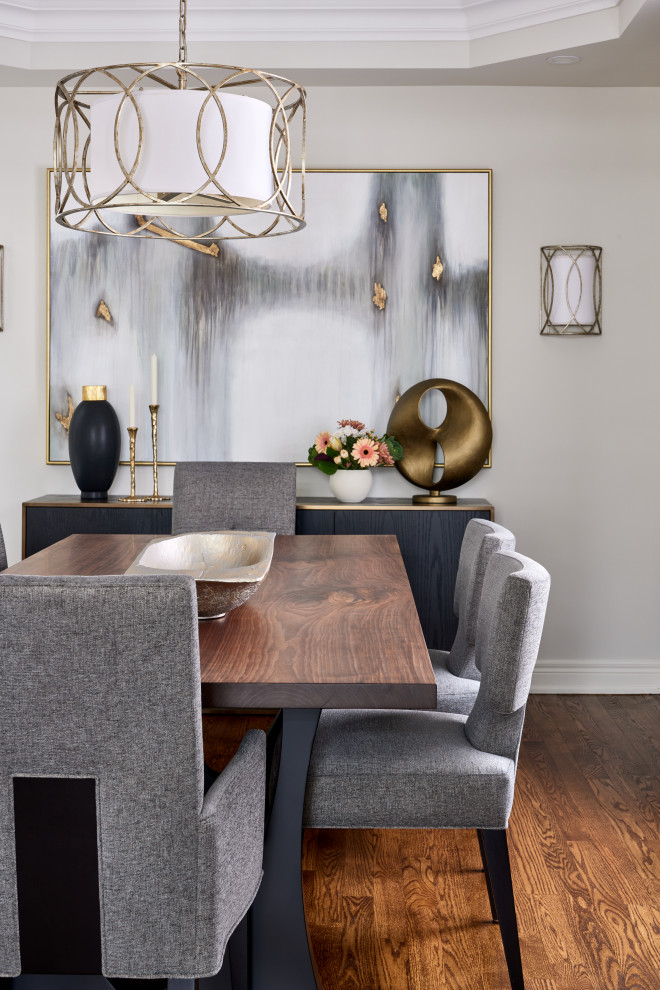Mid-sized trendy medium tone wood floor and brown floor enclosed dining room photo in Toronto with beige walls