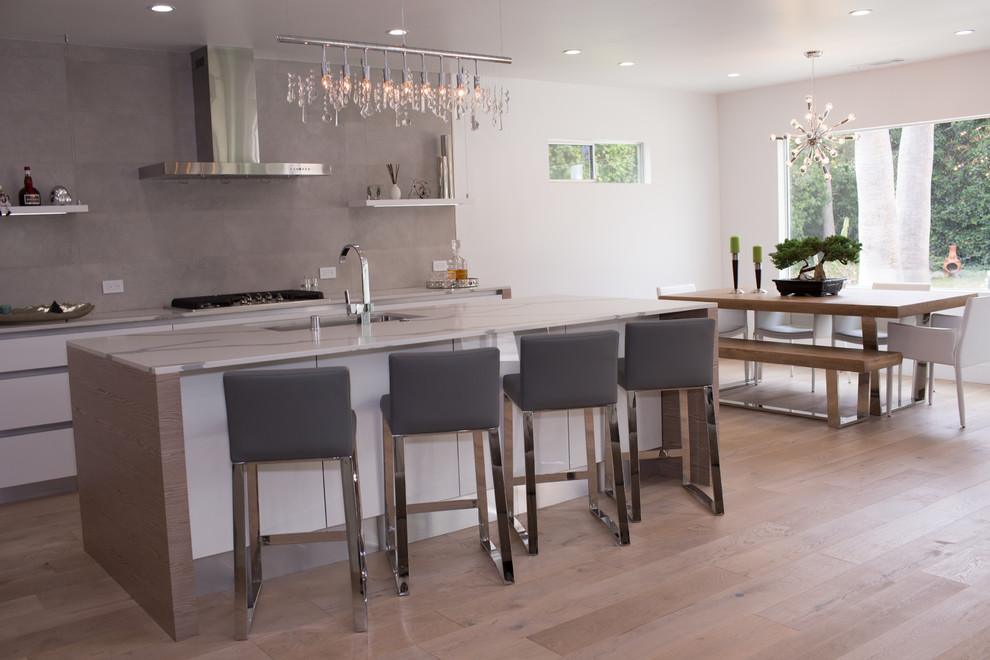 Mid-sized modern single-wall open plan kitchen in Seattle with a double-bowl sink, open cabinets, white cabinets, quartzite benchtops, grey splashback, marble splashback, stainless steel appliances, bamboo floors, with island and brown floor.