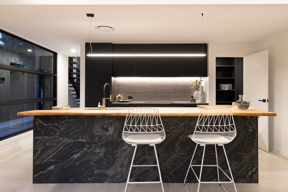 Inspiration for a contemporary galley kitchen in Brisbane with flat-panel cabinets, black cabinets, black splashback and with island.