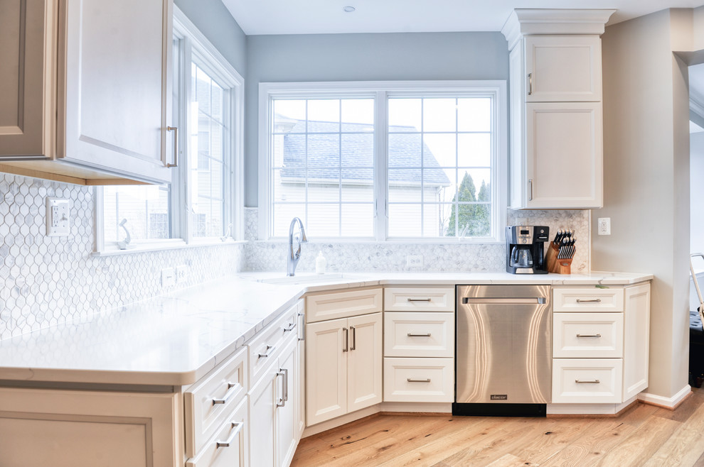 Example of a huge transitional galley light wood floor and brown floor eat-in kitchen design in DC Metro with an undermount sink, beaded inset cabinets, white cabinets, quartzite countertops, white backsplash, marble backsplash, stainless steel appliances, an island and white countertops