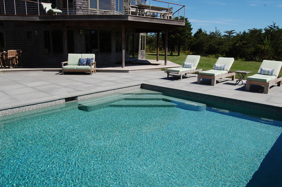 This is an example of a large contemporary backyard rectangular lap pool in Boston with a hot tub and tile.