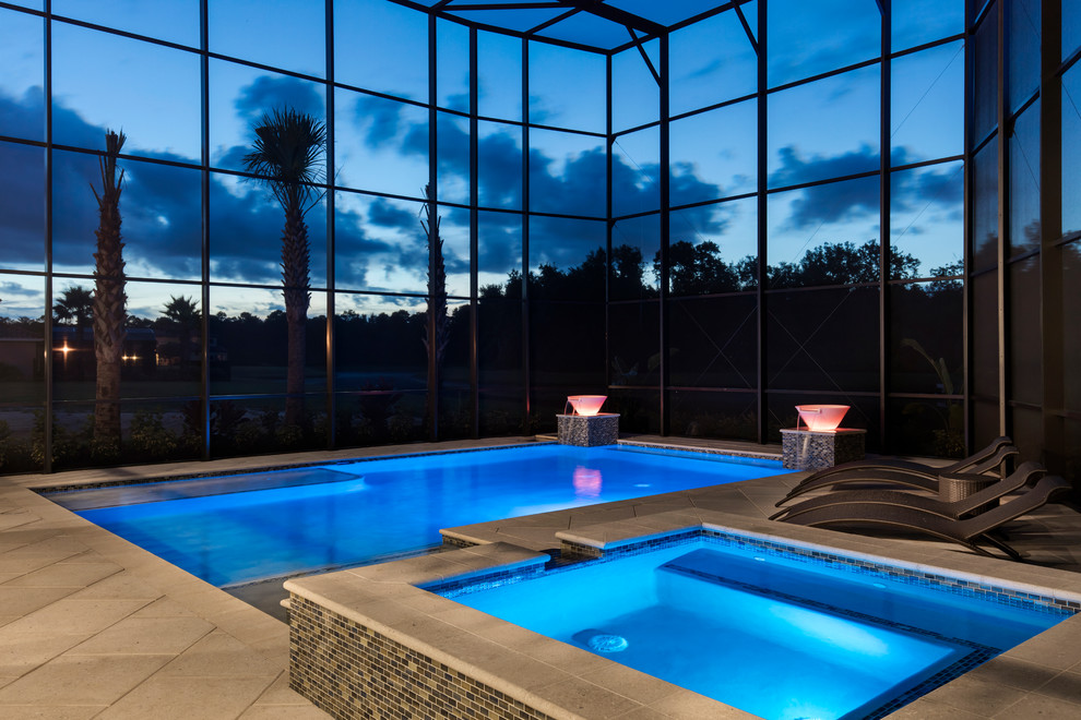 This is an example of a large modern backyard rectangular lap pool in Orlando with a hot tub and tile.