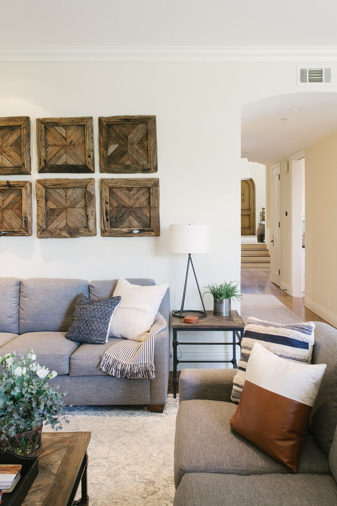 Inspiration for a large country enclosed family room in Santa Barbara with white walls, terra-cotta floors, a standard fireplace, a stone fireplace surround, a built-in media wall and brown floor.
