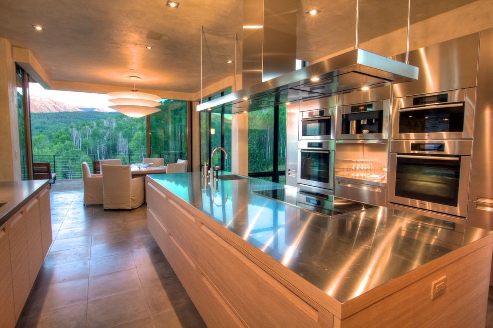 Contemporary galley eat-in kitchen in Denver with an integrated sink, flat-panel cabinets, light wood cabinets, stainless steel benchtops and stainless steel appliances.