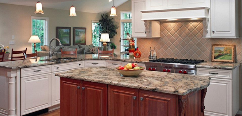 Example of a large l-shaped light wood floor eat-in kitchen design with beaded inset cabinets, white cabinets, granite countertops, beige backsplash, ceramic backsplash, stainless steel appliances and an island
