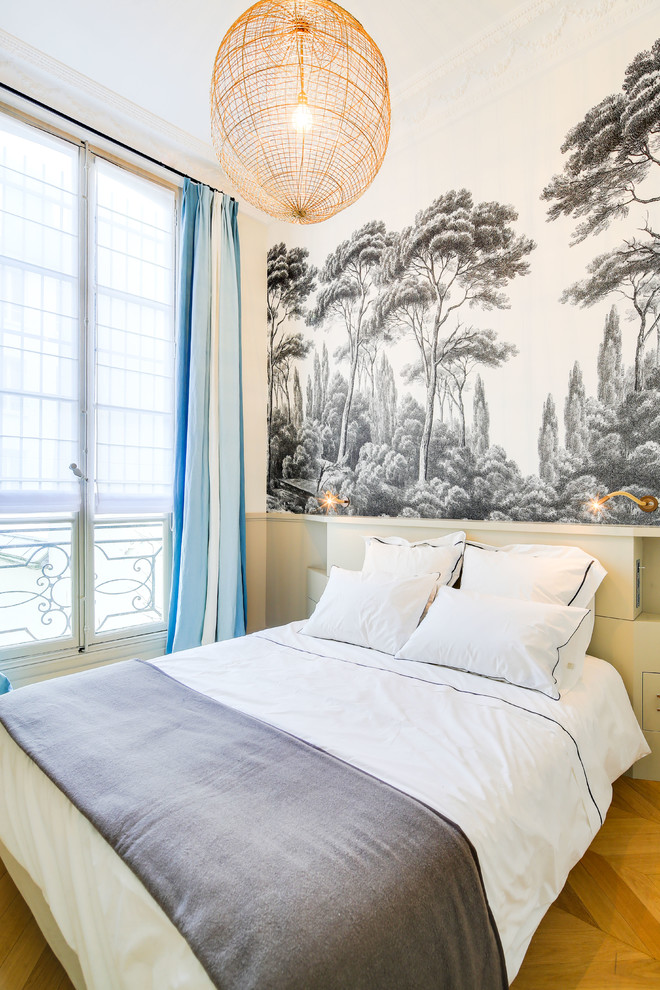 Design ideas for a contemporary guest bedroom in Paris with white walls, medium hardwood floors and brown floor.