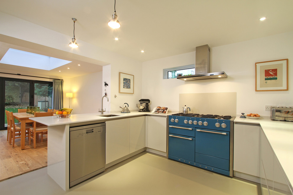 This is an example of a mid-sized modern u-shaped eat-in kitchen in Hampshire with coloured appliances, a single-bowl sink, flat-panel cabinets, white cabinets, quartz benchtops, beige splashback, glass sheet splashback, linoleum floors and a peninsula.