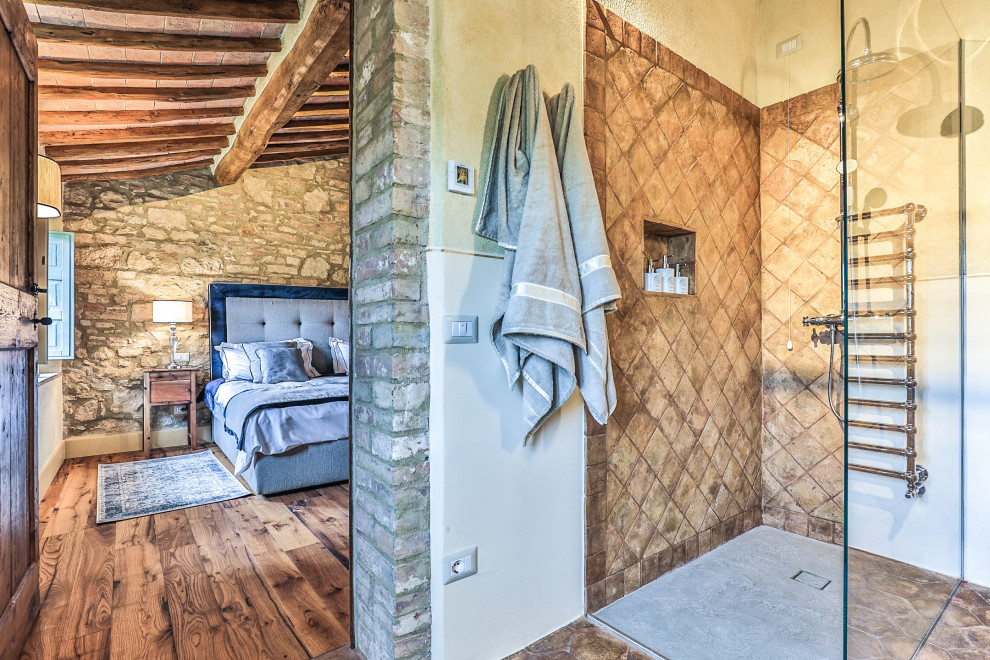 Immagine di un'ampia camera degli ospiti mediterranea con pareti gialle, pavimento in legno massello medio, nessun camino, pavimento marrone e soffitto in legno