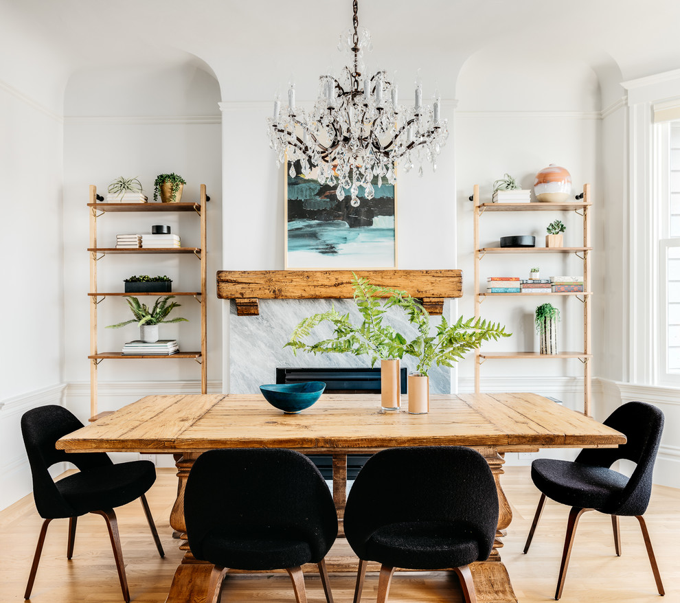 Photo of a scandinavian dining room in San Francisco with white walls, light hardwood floors, a standard fireplace and beige floor.
