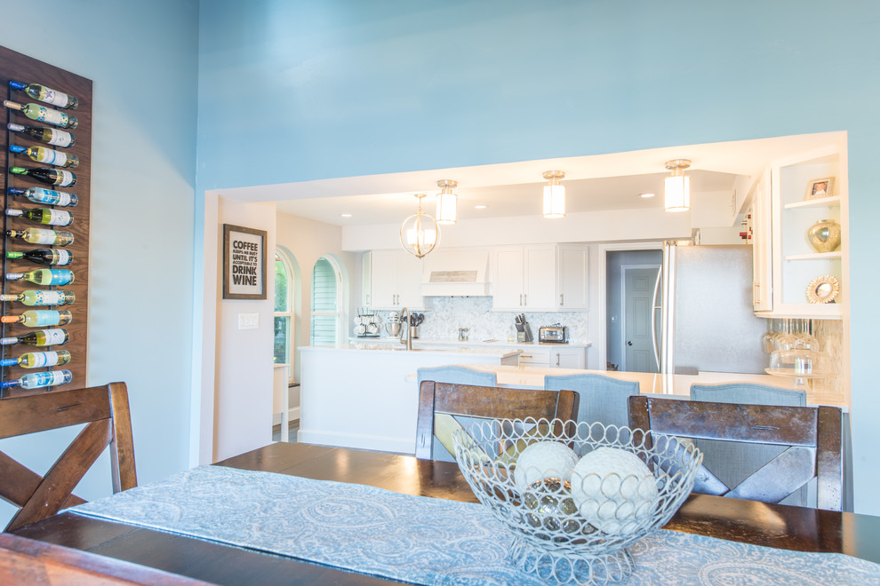 Large transitional u-shaped porcelain tile and brown floor eat-in kitchen photo with an undermount sink, shaker cabinets, white cabinets, quartz countertops, white backsplash, marble backsplash, stainless steel appliances and two islands