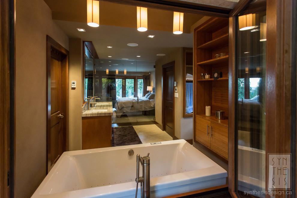This is an example of a large contemporary master bathroom in Vancouver with flat-panel cabinets, medium wood cabinets, a freestanding tub, beige walls, an undermount sink, engineered quartz benchtops and multi-coloured benchtops.