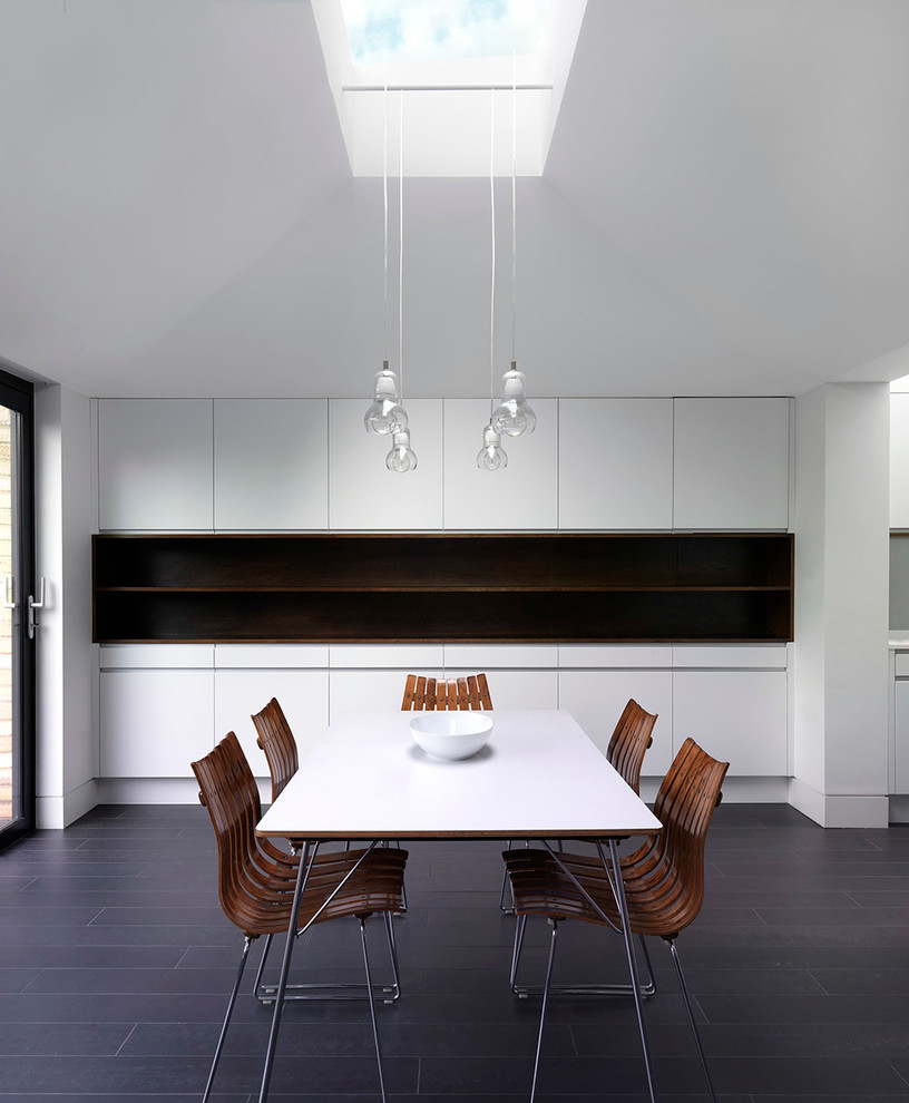 Inspiration for a contemporary dining room in London with white walls and dark hardwood floors.