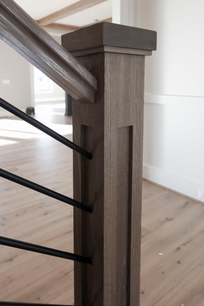 Пример оригинального дизайна: большая деревянная лестница на больцах в стиле ретро с деревянными ступенями и перилами из смешанных материалов