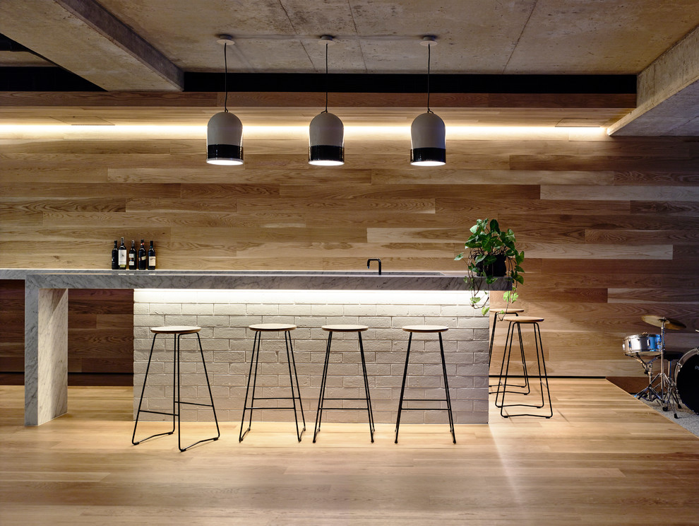 Photo of a large contemporary seated home bar in Melbourne with marble benchtops.