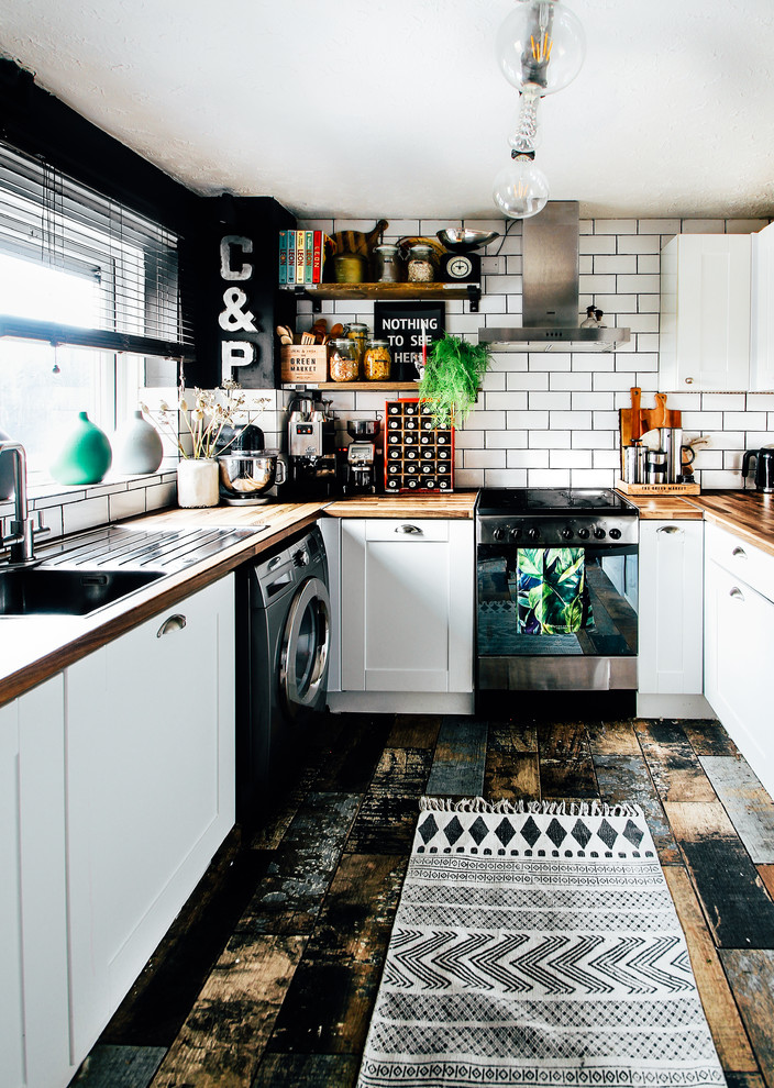 Inspiration for a small eclectic u-shaped separate kitchen in Cardiff with a single-bowl sink, shaker cabinets, white cabinets, laminate benchtops, white splashback, ceramic splashback, stainless steel appliances, multi-coloured floor and brown benchtop.
