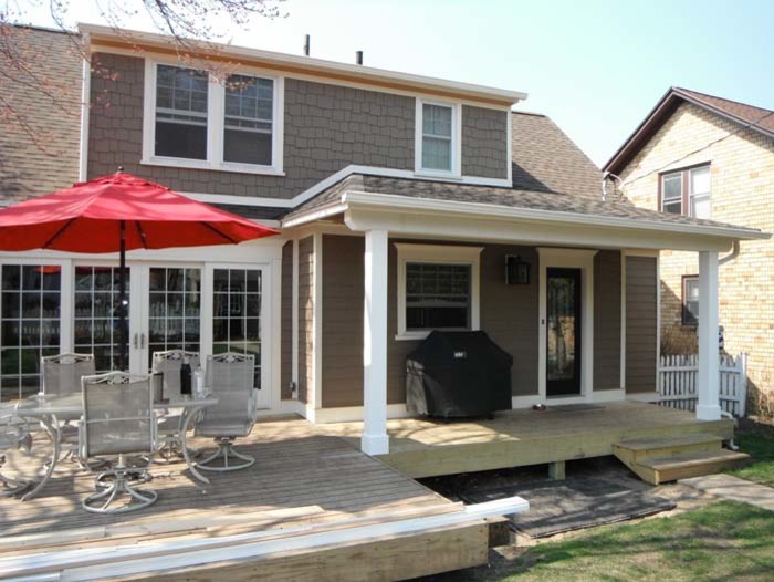 Example of a classic backyard outdoor kitchen deck design with a roof extension