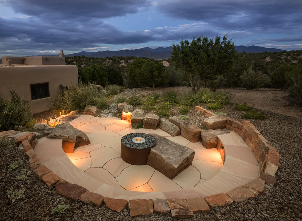 Design ideas for a mid-sized side yard patio in Albuquerque with a fire feature, natural stone pavers and no cover.