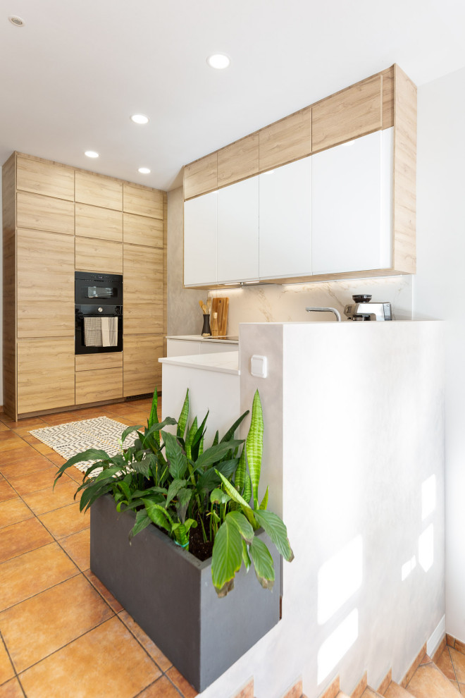 Bild på ett mellanstort funkis vit vitt u-kök, med en undermonterad diskho, släta luckor, vita skåp, bänkskiva i kvarts, vitt stänkskydd, integrerade vitvaror, terrazzogolv och rött golv