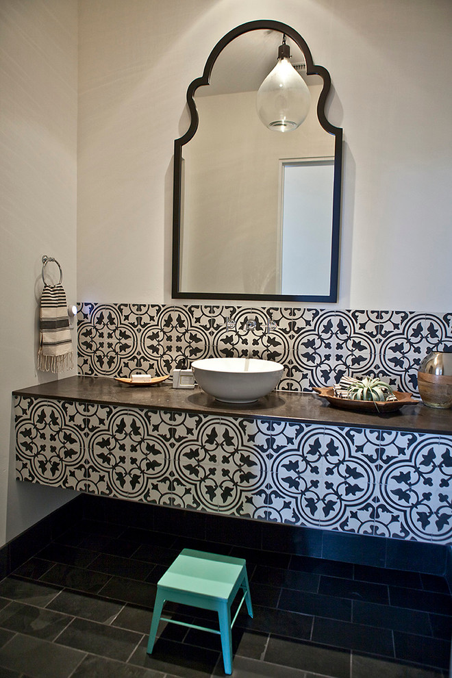 This is an example of a mid-sized mediterranean 3/4 bathroom in San Diego with a one-piece toilet, black and white tile, cement tile, white walls, slate floors, a vessel sink and granite benchtops.
