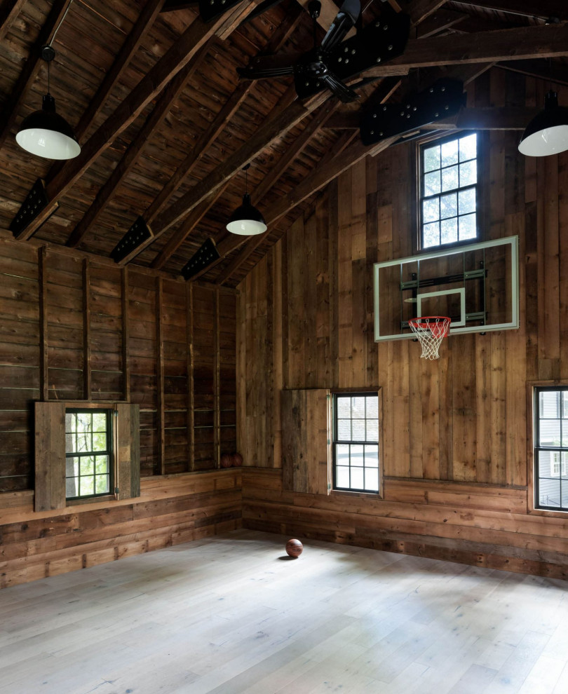 Landhausstil Fitnessraum mit Indoor-Sportplatz, brauner Wandfarbe, hellem Holzboden, beigem Boden, freigelegten Dachbalken, gewölbter Decke und Holzdecke in Boston