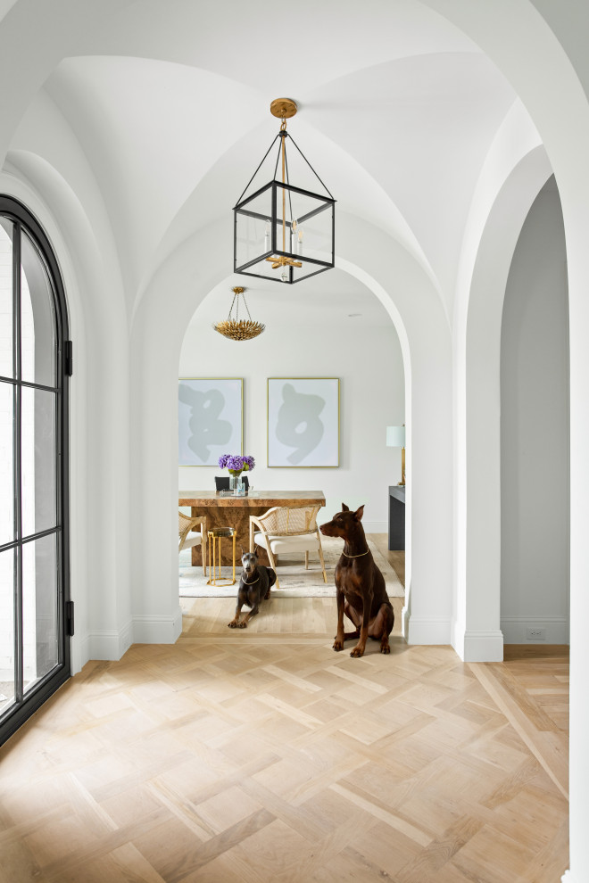 Inspiration for a large transitional light wood floor and brown floor foyer remodel in Dallas with white walls and a metal front door