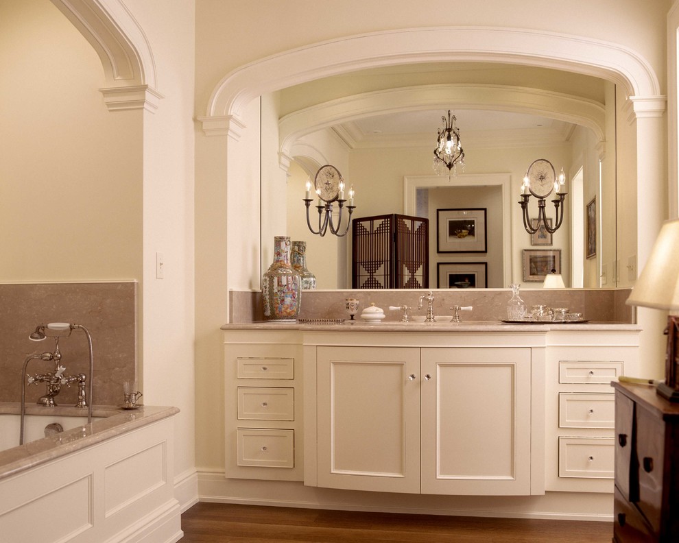 This is an example of a small traditional master bathroom in Portland with a vessel sink, recessed-panel cabinets, white cabinets, marble benchtops, an undermount tub, white walls and medium hardwood floors.