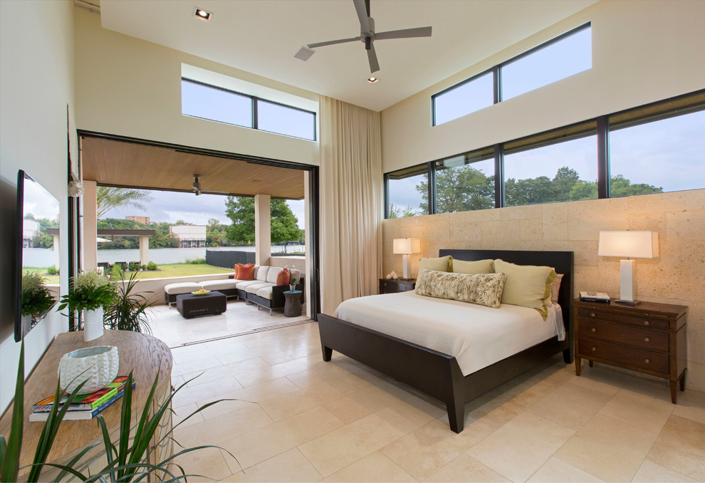 Large contemporary master bedroom in Austin with white walls, travertine floors and no fireplace.