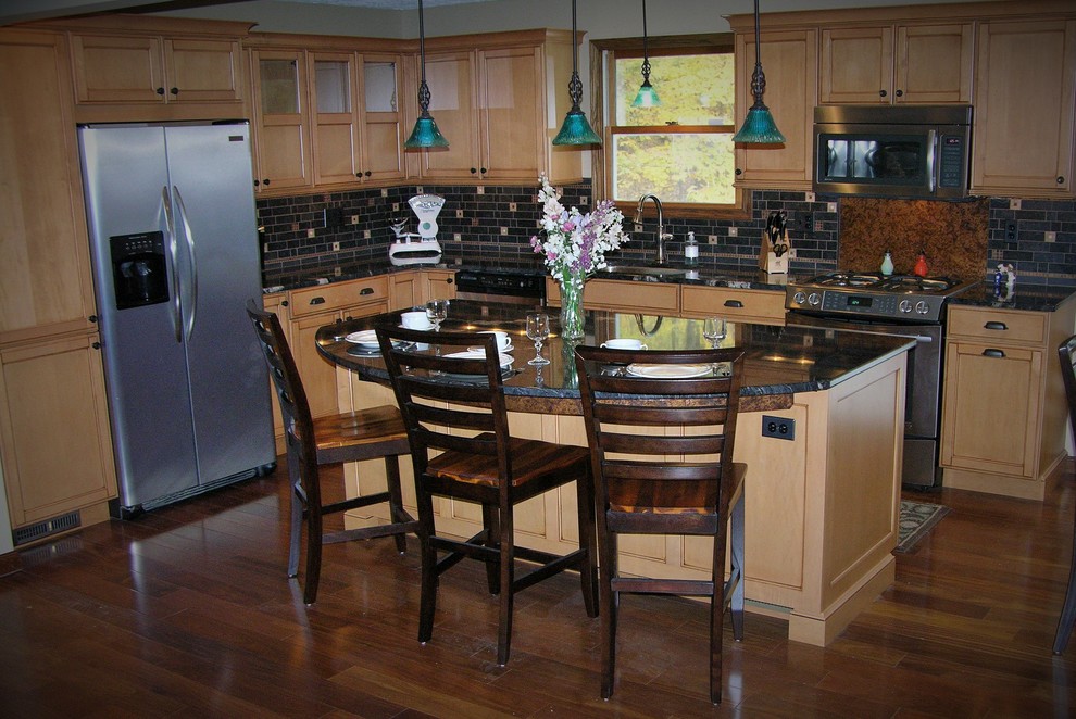 Example of a mid-sized transitional l-shaped dark wood floor and brown floor open concept kitchen design with an undermount sink, shaker cabinets, light wood cabinets, granite countertops, black backsplash, subway tile backsplash, stainless steel appliances and an island