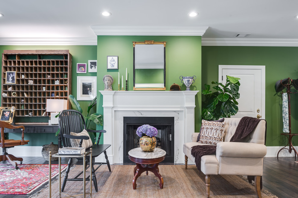 This is an example of a large tropical formal open concept living room in Atlanta with green walls, dark hardwood floors, a standard fireplace, a plaster fireplace surround, no tv and brown floor.