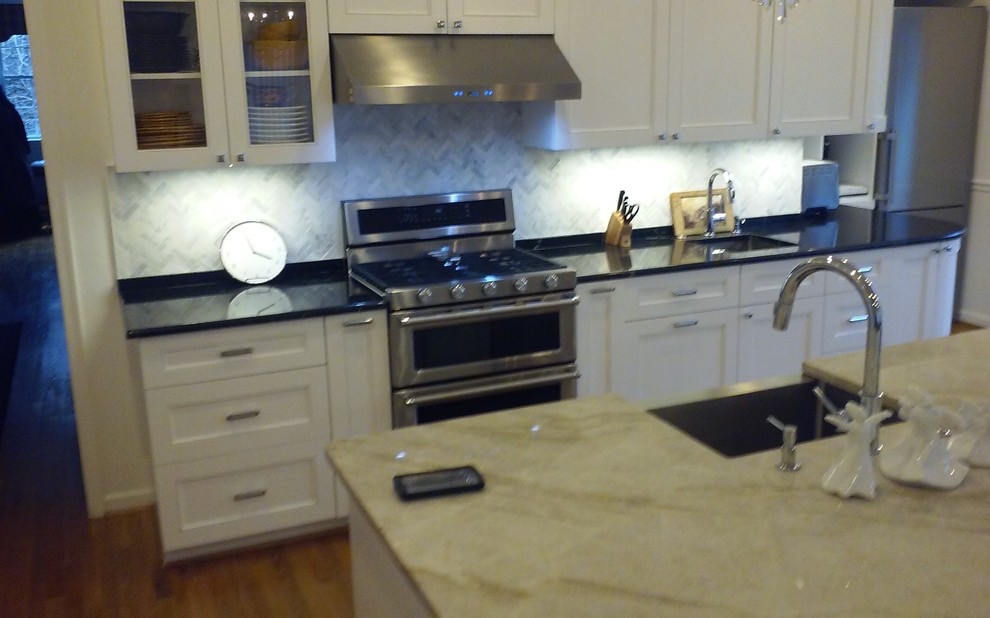 Eat-in kitchen - huge transitional light wood floor eat-in kitchen idea in Baltimore with a farmhouse sink, glass-front cabinets, white cabinets, granite countertops, gray backsplash, mosaic tile backsplash, stainless steel appliances and an island