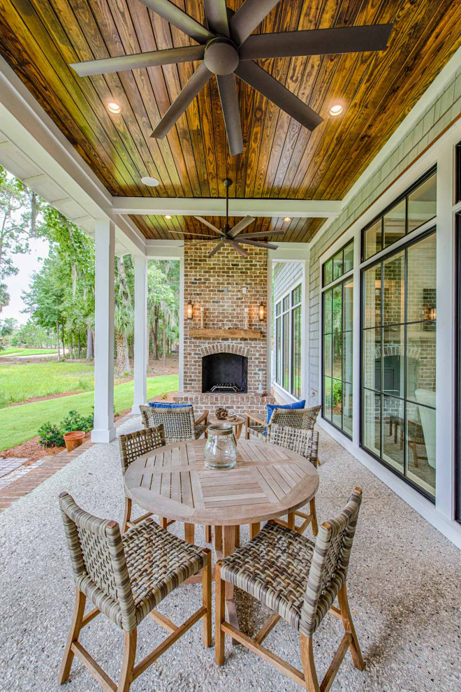 Idées déco pour un porche d'entrée de maison arrière avec une cheminée, des pavés en brique et une extension de toiture.