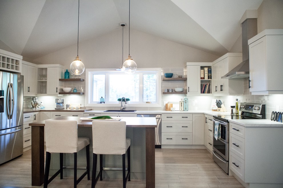 Inspiration for a mid-sized modern u-shaped medium tone wood floor and brown floor open concept kitchen remodel with shaker cabinets, white cabinets, quartz countertops, gray backsplash, an island, white countertops, a drop-in sink, ceramic backsplash and stainless steel appliances