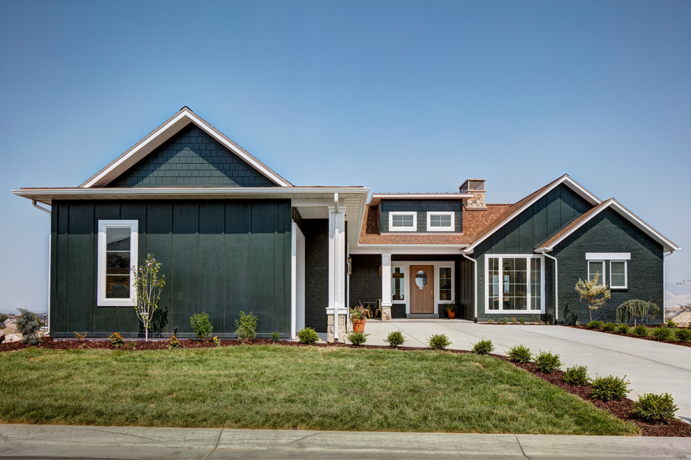 Photo of a large transitional one-storey green house exterior in Salt Lake City with mixed siding, a gable roof and a shingle roof.