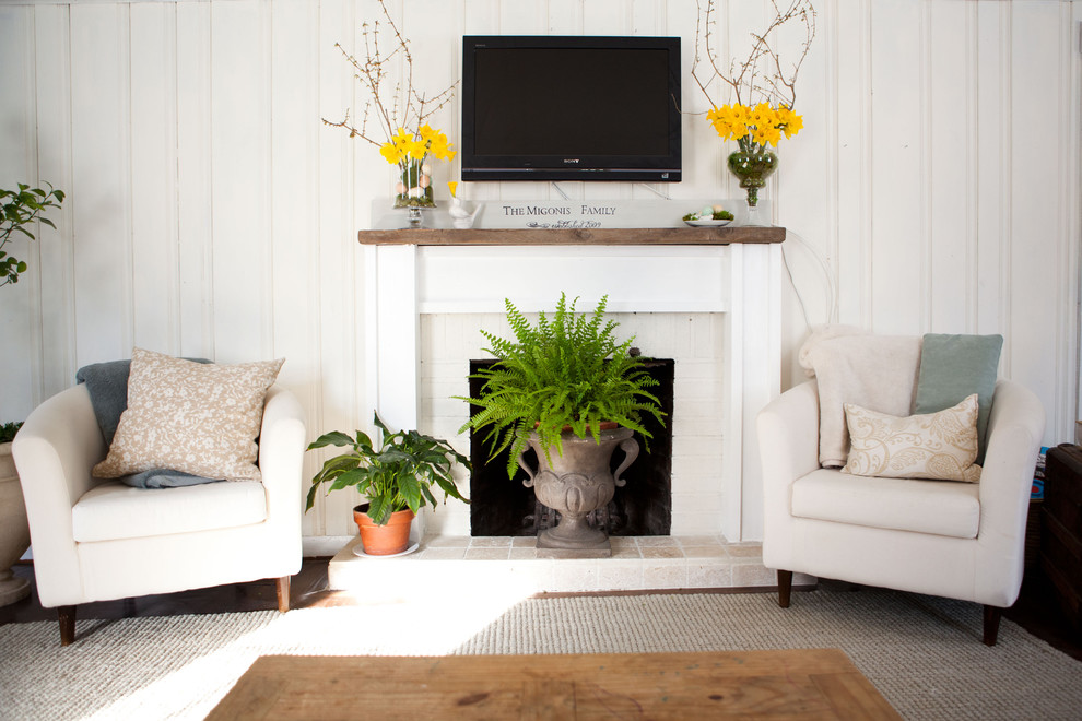 Photo of a traditional living room in Boston with a standard fireplace and a wall-mounted tv.