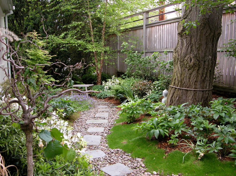 This is an example of a mid-sized asian backyard full sun garden for spring in Boston with a garden path and natural stone pavers.