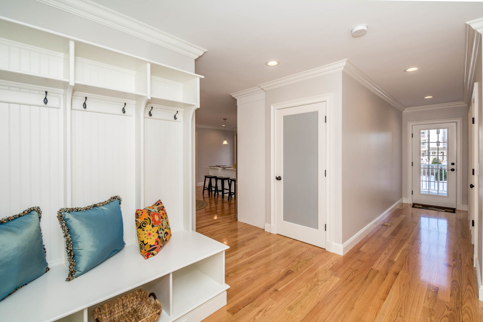 Inspiration for a mid-sized traditional mudroom in Boston with grey walls, a single front door, a medium wood front door, brown floor and medium hardwood floors.