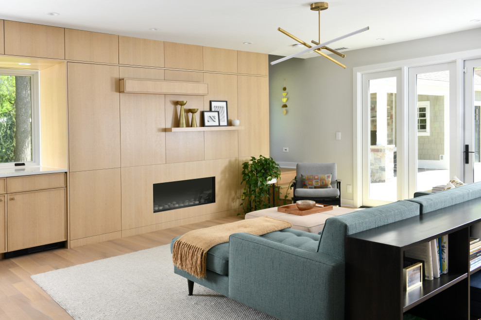 Example of a mid-sized trendy open concept light wood floor and beige floor living room design in Other with a standard fireplace, a wood fireplace surround and no tv