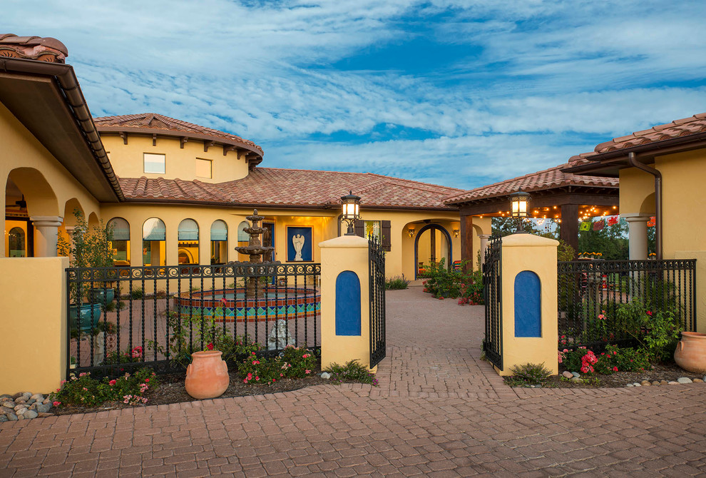 Design ideas for a two-storey stucco yellow exterior in San Diego with a gable roof.