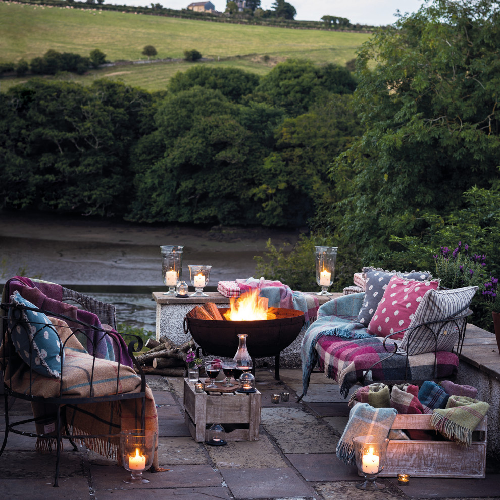 Mid-sized country courtyard patio in Devon with a fire feature.